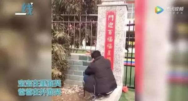 在幼儿园门口蹲下身子掩面哭泣,宝宝在里面哭,爸爸在外面哭