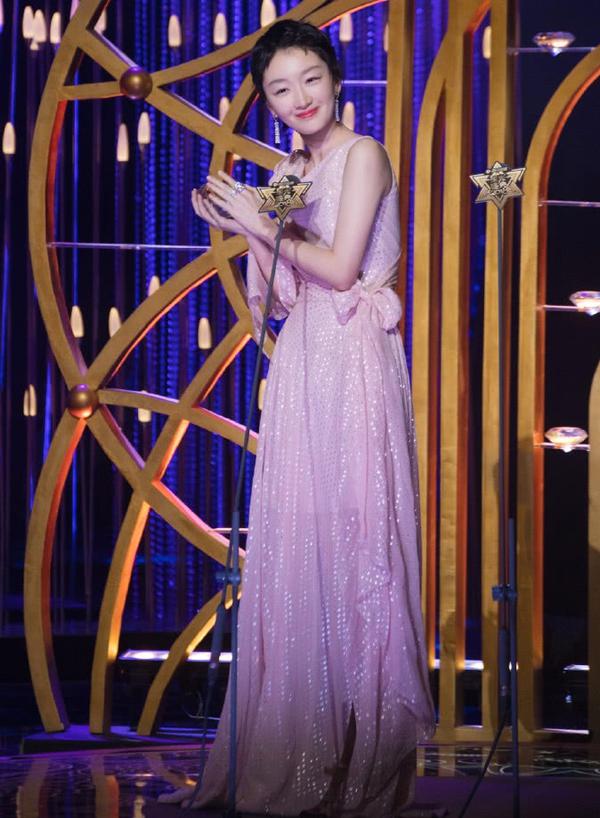 她穿上一件紫色的吊带连衣裙,裙子是束腰的设计,勾勒出周冬雨的身材