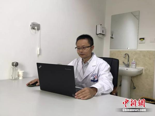 图为吸着氧气出门诊的郭卫刚