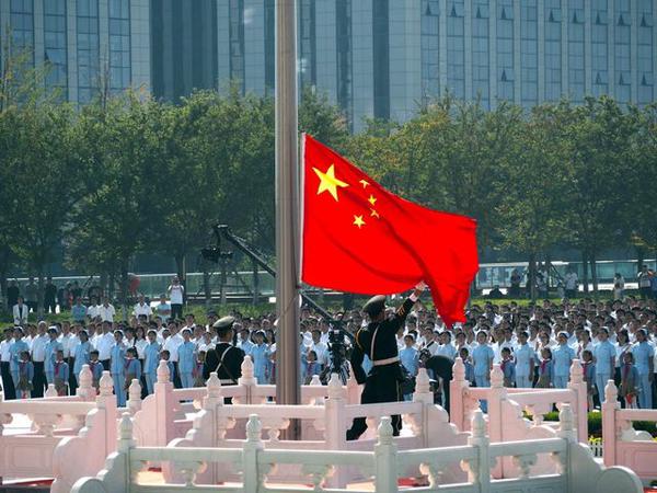 即墨区庆祝新中国成立70周年升旗仪式上,升旗手向空中挥舞国旗.