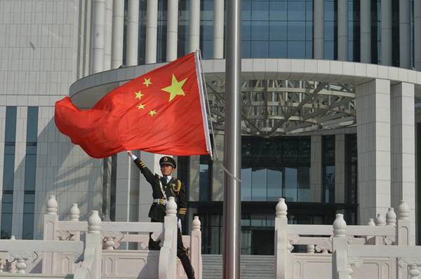 即墨区庆祝新中国成立70周年升旗仪式上,升旗手向空中挥舞国旗.