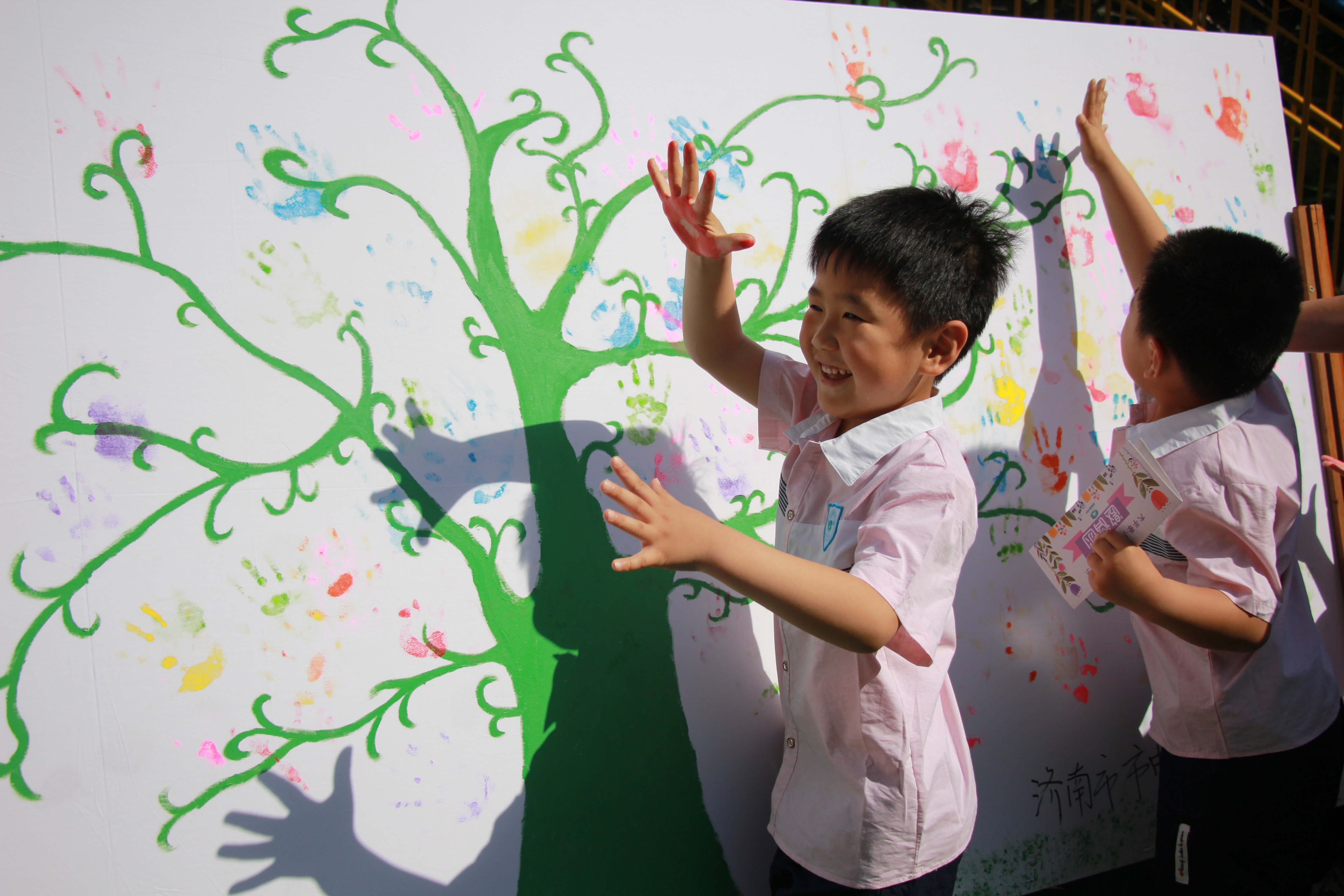 家长带领孩子签到,在成长树上按下孩子的手印留下永远的纪念.